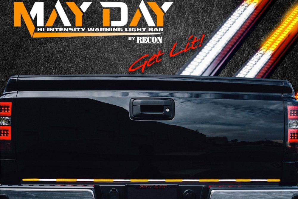 Image of black truck tailgate with LED taillights. The text reads, "May Day. Hi Intensity Warning Light Bar by RECON. Get Lit!'