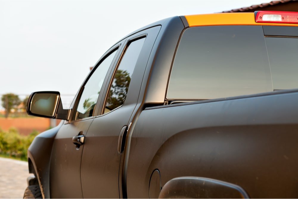 Rear/Side view of a matte black pickup truck, with third brake light visible.