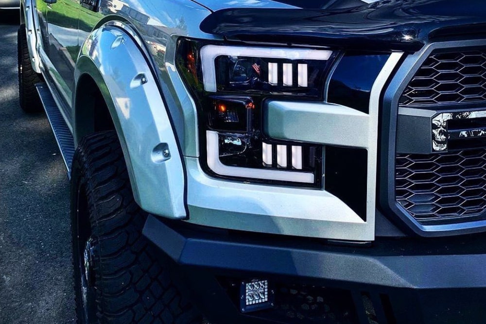 Close up picture of one cool looking headlight on a white SUV.